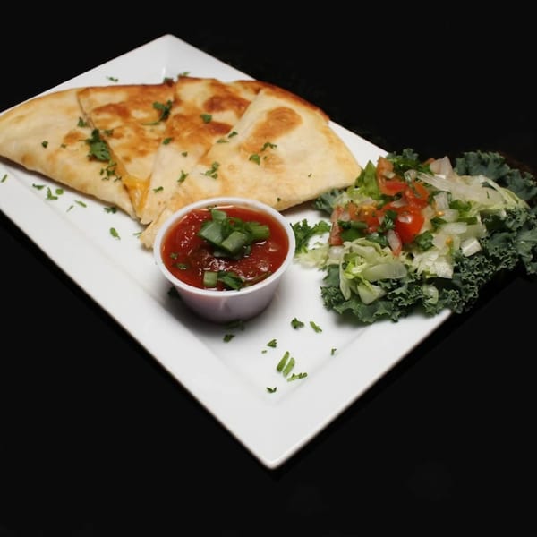 Golden-brown quesadilla triangles with salsa and a side salad on a white rectangular plate.