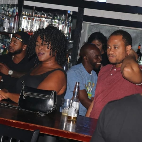 Patrons enjoying drinks at the Empire Lounge bar, with bottles of liquor visible in the background.
