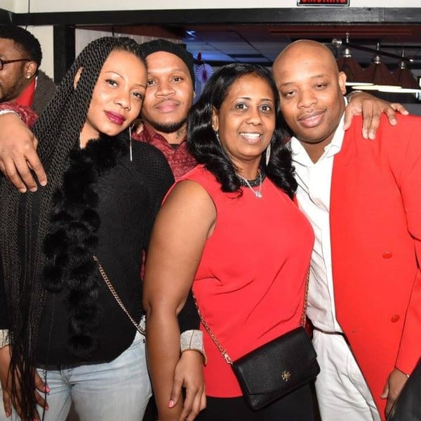 Four smiling people, two men and two women, posing together at Empire Lounge.
