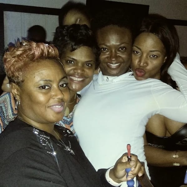 Four women smiling and posing closely together at Empire Lounge, one holding a hookah hose.
